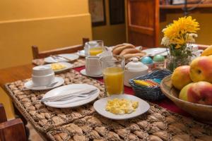 una mesa cubierta con platos de comida y fruta en CASA HOSPEDAJE EL LABRADOR en Cusco