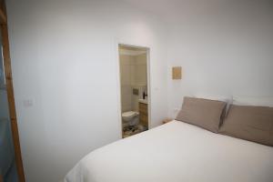 1 dormitorio con cama blanca y baño en Maisonnette centre de Saint Dizier, en Saint-Dizier