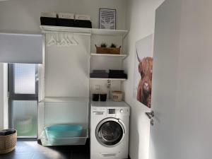 - un lave-linge et un sèche-linge dans une buanderie blanche dans l'établissement Moderne 70 qm Ferienwohnung in Waldrandlage, à Eppelborn