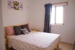 a bedroom with a large bed with a window at Cosy & Relax Yellow House 5mn walk from the beach! in Calheta Do Maio
