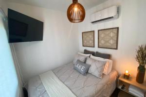 a small room with a bed and a tv at Villa Exclusiva para parejas en Puerto Rico in Villalba