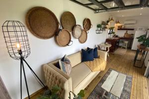 a living room with a couch and baskets on the wall at Villa Exclusiva para parejas en Puerto Rico in Villalba