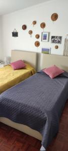 a bedroom with two beds and pictures on the wall at Santo António's Guesthouse in Cascais