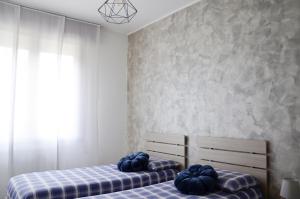 Duas camas num quarto com almofadas azuis em Appartamento Ciclamino em Mestre