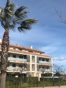 uma palmeira em frente a um edifício em Apartment Panoramica Golf em Sant Jordi
