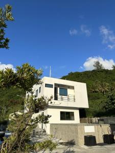 una casa blanca en la cima de una colina en Oceans Explore Hostel en Green Island