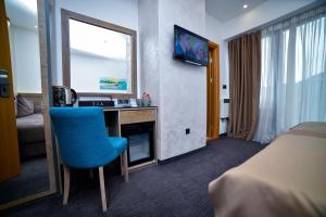 una camera d'albergo con scrivania e sedia blu di Apartman Milinović Zlatibor - Hotel Alibi a Zlatibor