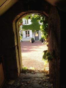 een boog in een gebouw met een tuin bij Domaine d'AROMM in Ouches