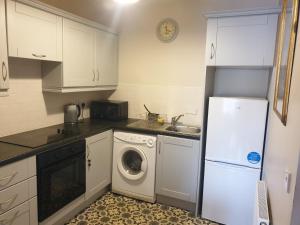 a kitchen with a white refrigerator and a washing machine at Kilkenny City Apartment in Kilkenny