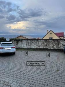 a car parked in a parking lot next to a wall at Apartmán Dominika Bojnice in Bojnice