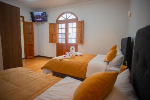 1 Schlafzimmer mit 2 Betten, einem TV und einem Fenster in der Unterkunft Hostal TELSA SWEET STAY Inkahoteles in Arequipa
