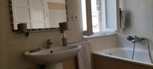 bagno con lavandino, vasca e specchio di CASAMIASIROLO - Casa nei vicoli di Sirolo a Sirolo