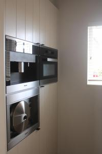 a kitchen with two ovens in a wall at Maison Margareta in Middelburg