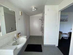 a white bathroom with a sink and a shower at Colonial Motel in Blenheim