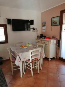 a kitchen with a table with chairs and a sink at Il Nido in Olbia