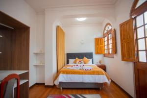 1 dormitorio con 1 cama con manta naranja en Hostal TELSA SWEET STAY Inkahoteles, en Arequipa