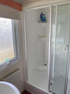 a white bathroom with a shower and a sink at ST BREAKS BY THE BEACH in Ingoldmells