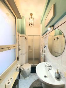 a bathroom with a toilet and a sink and a mirror at Alma Vacation Apartment in the centre, big terrace in Milan