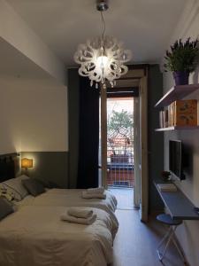 a bedroom with two beds and a chandelier at Alma Vacation Apartment in the centre, big terrace in Milan