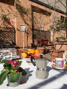 a table with a plate of fruit and a tea pot at Alma Vacation Apartment in the centre, big terrace in Milan