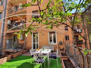 a patio with a table and chairs in front of a building at Alma Vacation Apartment in the centre, big terrace in Milan