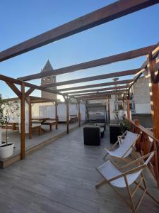 een terras met stoelen en tafels op een dak bij La Villa del Sastre in Vélez-Málaga