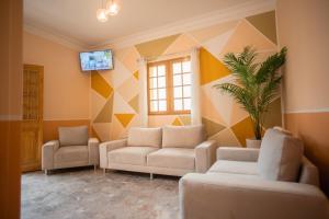 sala de estar con 2 sofás y TV en Hostal TELSA SWEET STAY Inkahoteles, en Arequipa