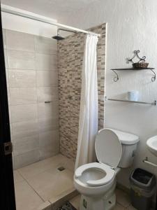 y baño con aseo blanco y ducha. en Casa Zona Iteso, Expo, Plaza del Sol, 4 habitaciones 8 huespedes / compartida en Guadalajara