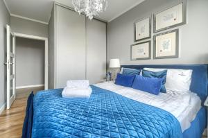 a bedroom with a blue and white bed with blue pillows at EXCLUSIVE Polonia Apartments in Szczecin