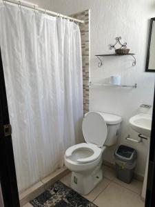 a white bathroom with a toilet and a sink at Casa Zona Iteso, Expo, Plaza del Sol, 4 habitaciones 8 huespedes / compartida in Guadalajara