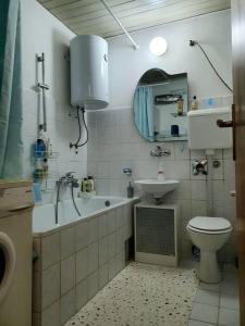 y baño con aseo, bañera y lavamanos. en Apartman Dukat Vukovar en Vukovar