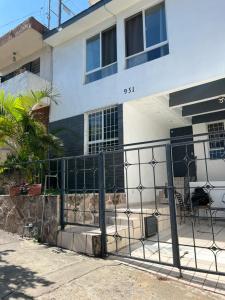 una casa con una valla delante de ella en Casa Zona Iteso, Expo, Plaza del Sol, 4 habitaciones 8 huespedes / compartida en Guadalajara