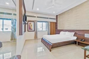 1 dormitorio con 1 cama y TV. en Hotel Sai Sparsh, en Shirdi