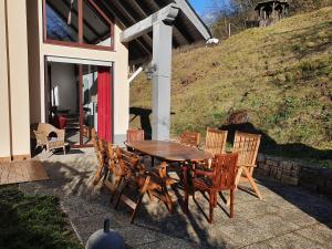 einen Holztisch und Stühle auf einer Terrasse in der Unterkunft Großes Ferienhaus Sauerburgblick in Sauerthal