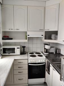 a kitchen with white cabinets and a stove top oven at M Apartments Lamminpää in Tampere