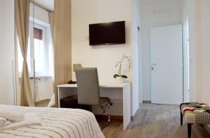 een slaapkamer met een bed en een bureau met een computer bij Minerva Rooms in Pavia