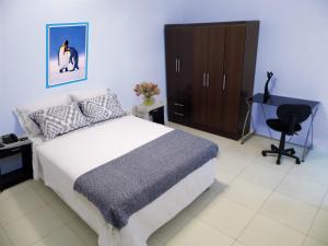 a bedroom with a bed and a desk and a chair at Magicperu Apart Hotel in Trujillo