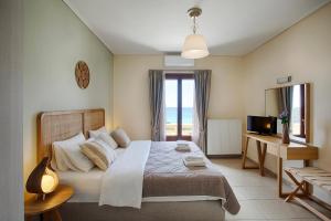 a bedroom with a large bed and a television at Aithra -Agios Petros Andros in Gavrio