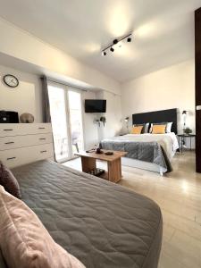 a bedroom with two beds and a desk and a tv at Hermes New & Comfy Studio - 25' walk to the Acropolis in Athens