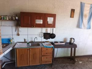 una cocina con armarios de madera y fregadero en Complejo Remitur en Puerto Iguazú