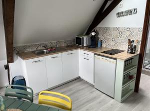 een kleine keuken met witte kasten en een magnetron bij Appartement Le Saint haut Centre ville à Saint-Omer in Saint-Omer
