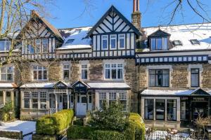 a large brick house with snow on the roof at ScandicStay-Apartment Harrogate in Harrogate