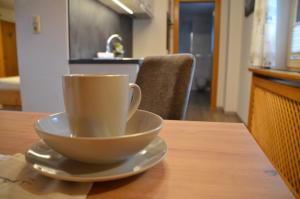 una taza de café sentada en un plato sobre una mesa en Haus Gerlinde, en Lermoos