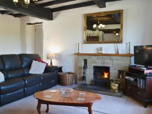 a living room with a couch and a fireplace at Kiln Green Farmhouse in Milnthorpe