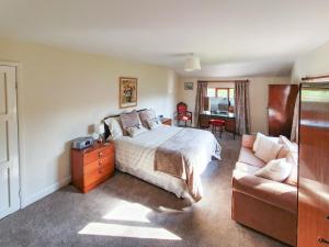 a bedroom with a bed and a couch at Kiln Green Farmhouse in Milnthorpe