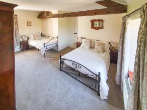 a bedroom with two beds and a mirror at Kiln Green Farmhouse in Milnthorpe