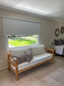 a couch in a room with a window and a bed at La Franca Aparts in Villa General Belgrano +29 photos
