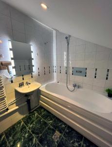 baño con bañera grande y lavamanos en Villa AdaMar - masaże & jacuzzi, en Ciechocinek