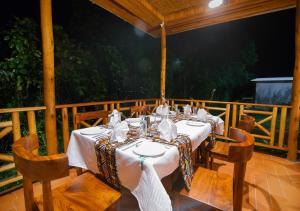 einen Tisch für eine Mahlzeit auf einer Veranda in der Unterkunft Gorilla Leisure Lodge in Kisoro