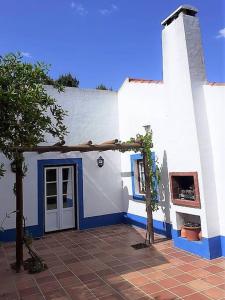 un edificio blanco y azul con puerta en Casa do Pinheiro, en Alcácer do Sal